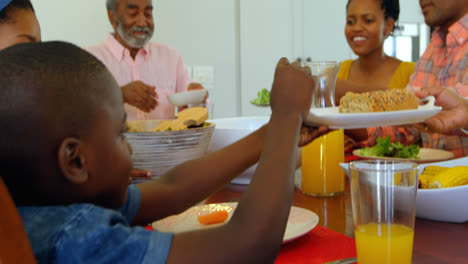 Vista-Lateral-De-Una-Familia-Negra-De-Varias-Generaciones-Comiendo-En-La-Mesa-Del-Comedor-En-Una-Casa-Cómoda-4k