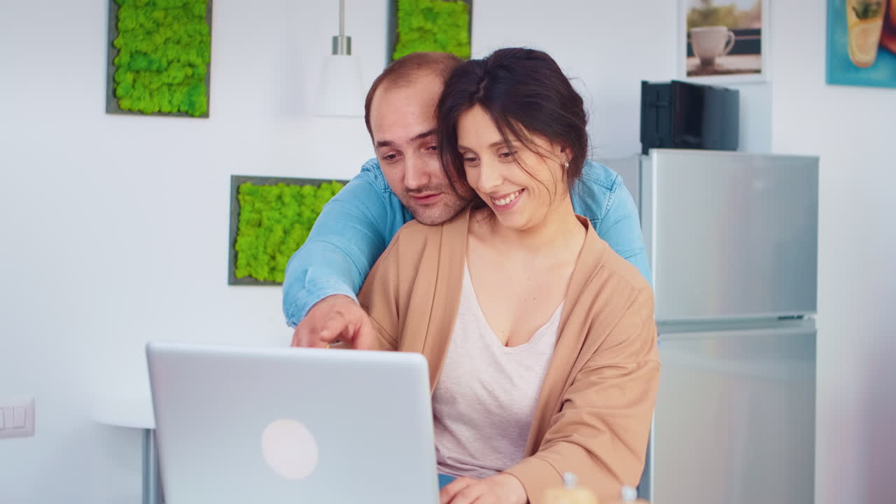 una pareja alegre usando una computadora portátil