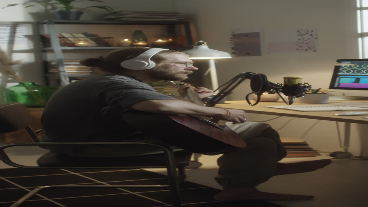 Musician Recording Song with Guitar in Home Studio