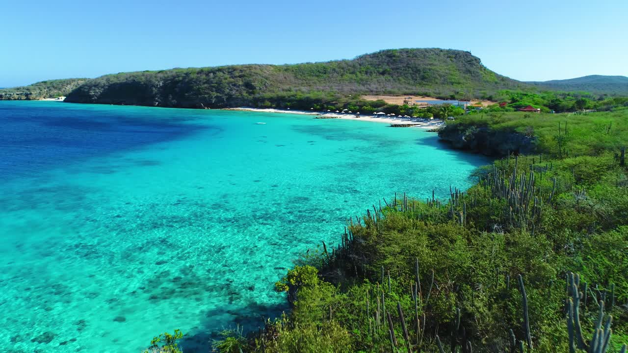 드론은 쿠라사오의 차가운 물을  ⁇ 아내기 위해 바위  ⁇ 투스 해안선 위로 밀어 넣습니다.