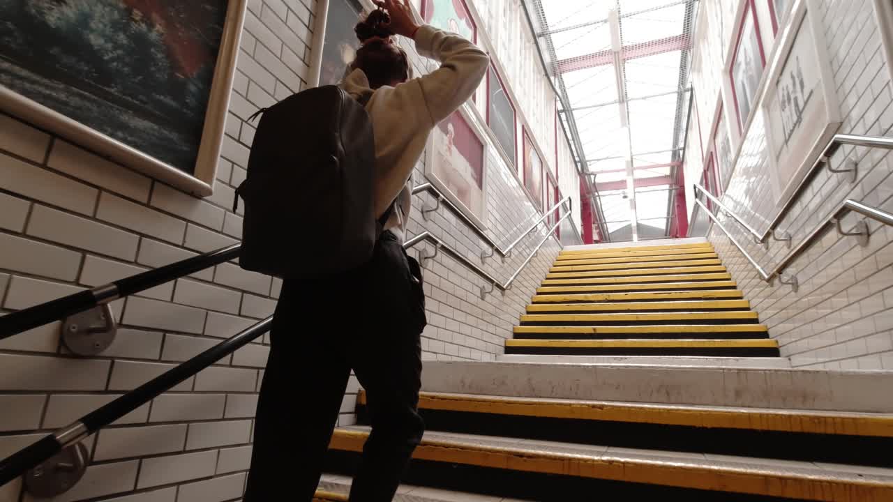 Young woman walking up the stairs of tube station in London