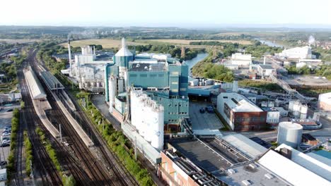 industrial chemical manufacturing factory next to warrington bank quay train tracks aerial view rising tilt down