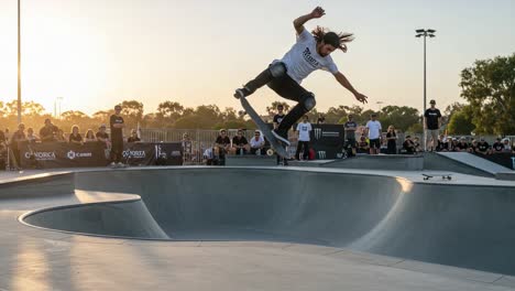 a dynamic display of skateboarding skills: a skater captivates the crowd with a complex trick over the concrete bowl at sunset