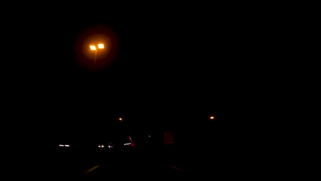 pov conduciendo un coche en la carretera iluminada a través de las luces en la noche