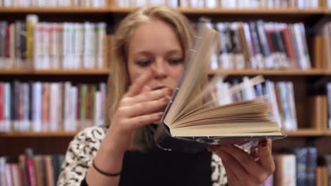 beautiful young girl is closing opened book, side shot, neutral look