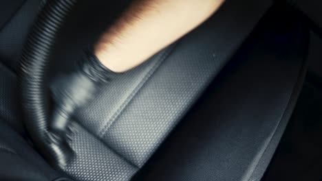 Close-up-of-a-male-wearing-black-gloves-vacuum-an-black-interior-car