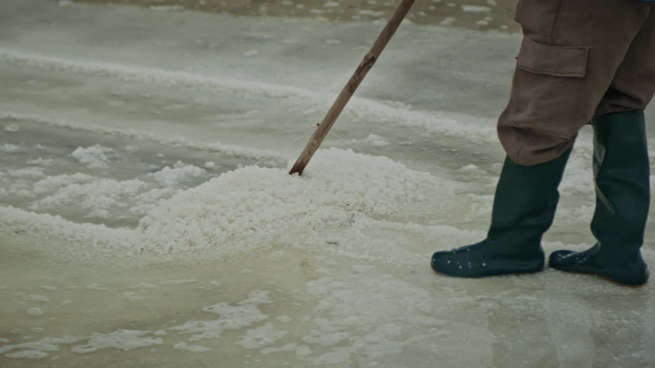 Worker harvesting salt in a salt farm