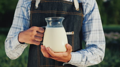 the farmer holds a jug with milk organic products concept