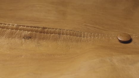 brown leather fashion jacket texture with stitched button seams slide shot