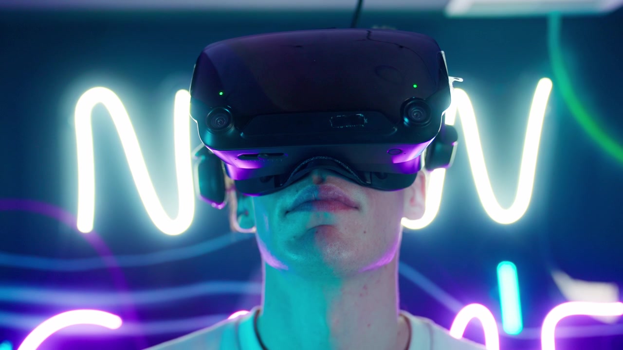 Giovane uomo immerso nella realtà virtuale con luci al neon
