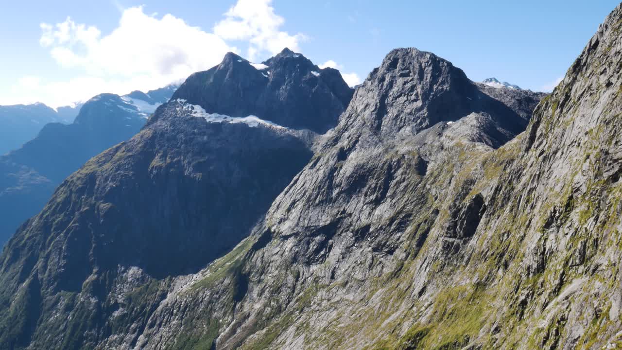 vista panorámica en la cima de la montaña que muestra la enorme iluminación de la cordillera por el sol en el parque nacional de fiordland, nueva zelanda