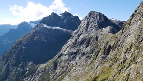 Panorama-view-on-top-of-mountain-showing-massive-mountain-range-lighting-by-sun-in-Fiordland-National-Park,New-Zealand