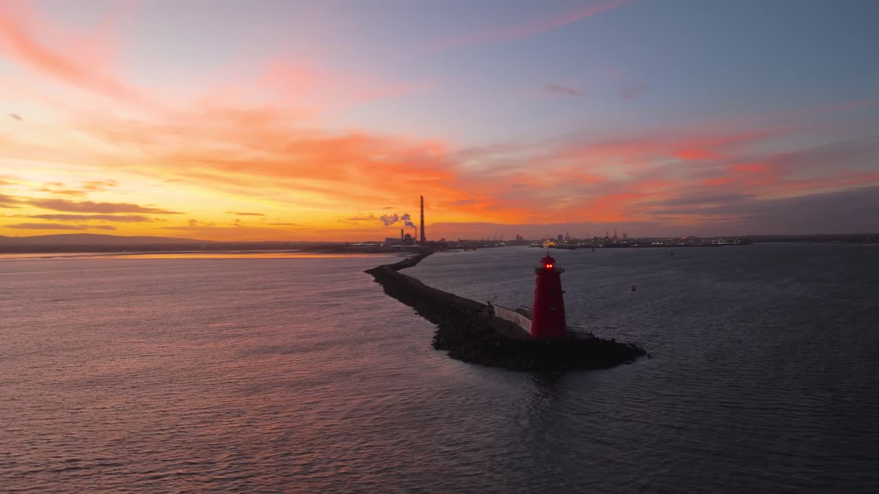 4K-videos med cinematiskt drönarfilmmaterial som fångar den ikoniska Poolbeg-fyren och Poolbeg-skorstenarna i Dublin under en hisnande solnedgång, badade i intensiva gyllene timmens färger_57