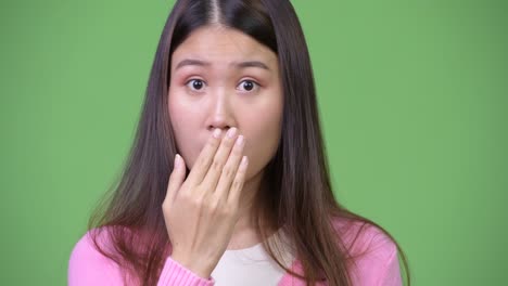 young beautiful asian woman looking shocked