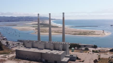 Aerial-wide-panning-shot-of-the-derelict-Morro-Bay-Power-Plant-near-Morro-Rock-on-the-edge-of-Morro-Bay,-California