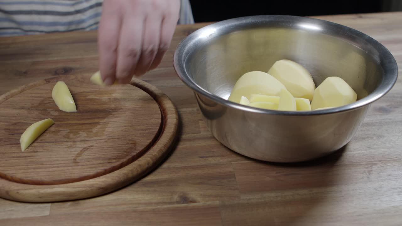 un chef pone rebanadas de patatas crudas en un plato