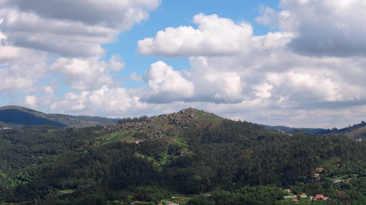 vista aérea de una colina verde exuberante bajo un cielo azul con nubes en minho, portugal