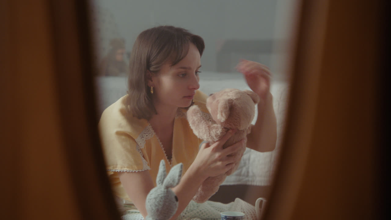 A girl playing with dolls in her room