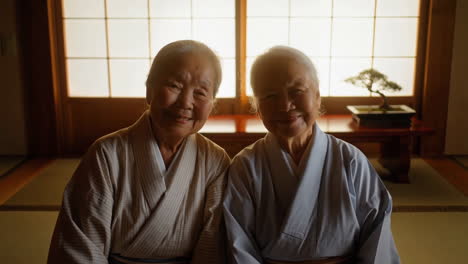 two elderly japanese women smiling in a traditional room