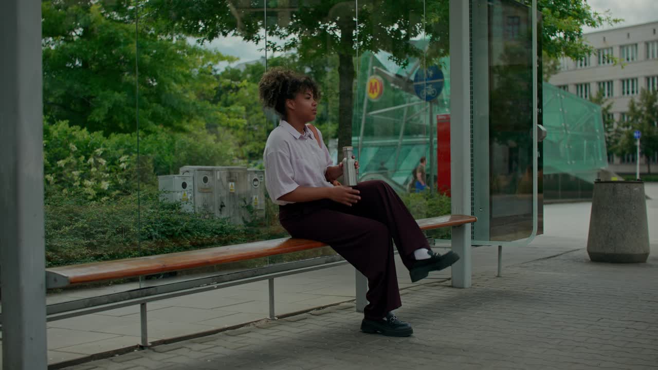 Donna che aspetta alla fermata dell'autobus in città