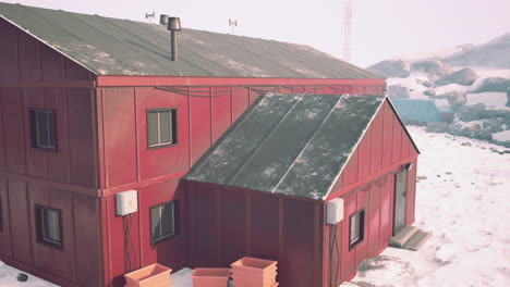 a red building in a snowy landscape, likely in antarctica