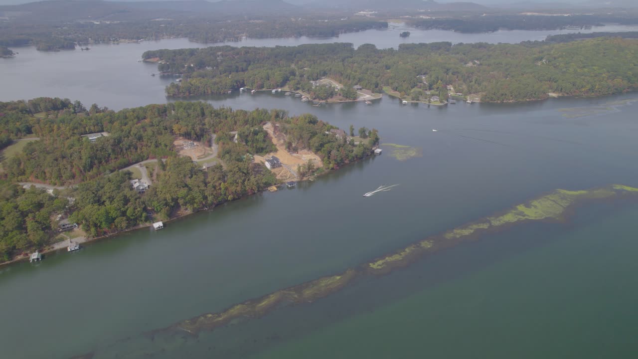 órbita aérea sobre el lago guntersville cerca de scottsboro, al durante el otoño con barco de velocidad conduciendo a través