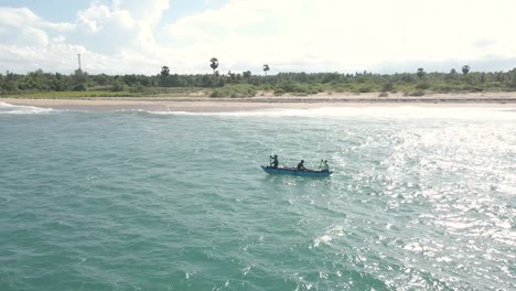 Beautiful-Cinematic-Aerial-Drone-Shot-of-Men-Rowing-on-a-Traditional-Canoe-on-Tropical-Ocean-Waters-on-a-Warm-Sunny-Day