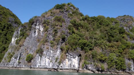 Berginseln-Der-Halong-Bucht-In-Vietnam,-Bestehend-Aus-Kalkstein-Karstformationen-Mit-Klarem-Himmel-Und-Starkem-Sonnenschein,-Schwenk-Nach-Links-Zeigt-Die-Aufnahme