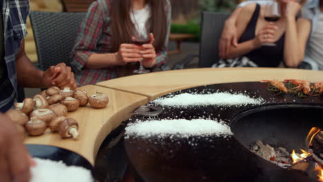 Man-hands-grilling-food-for-bbq-party-outside.-Guy-pouring-salt-on-grill