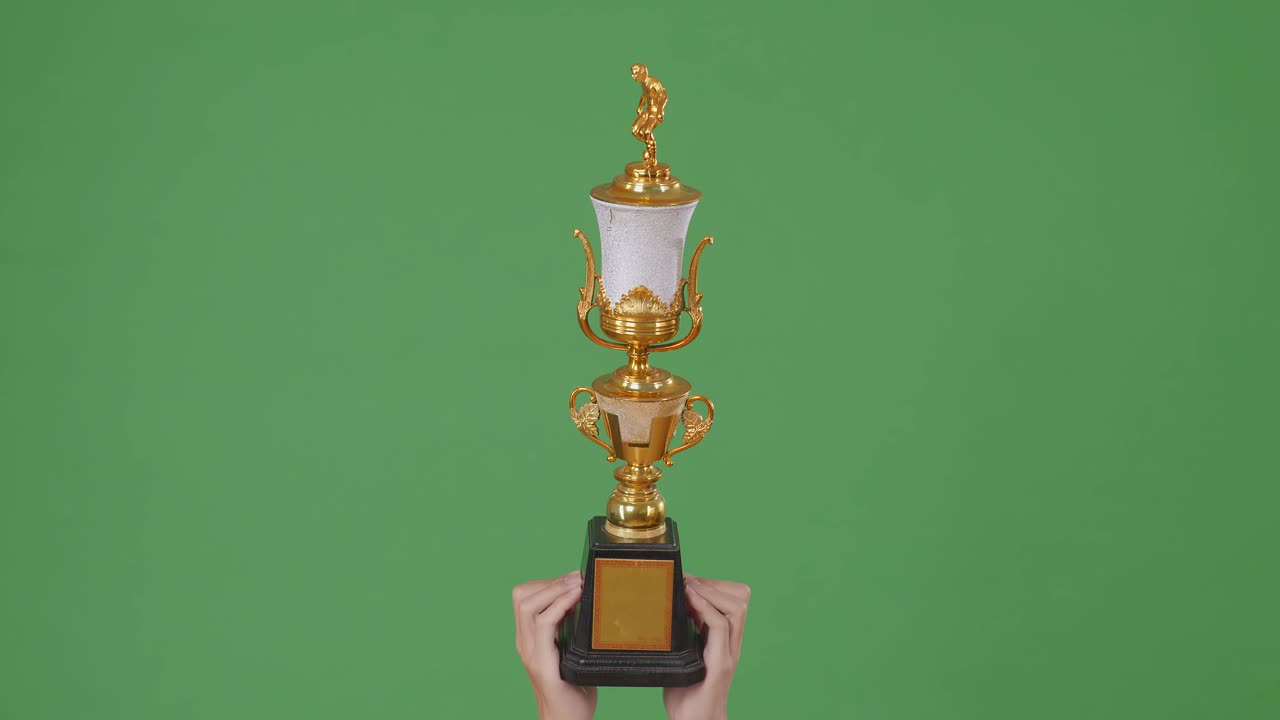 trofeo de oro en la mano en la pantalla verde