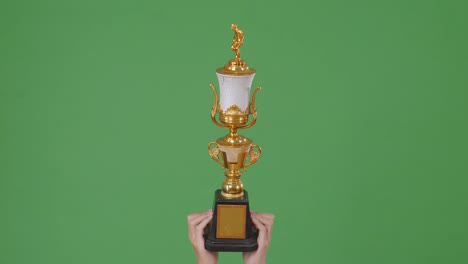 handheld gold trophy on green screen