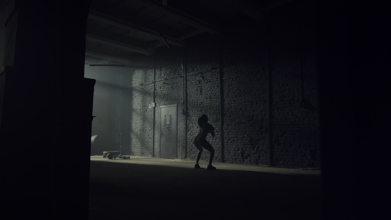 mujer deportista que lanza una pelota en forma contra una pared de hormigón en un edificio de ático