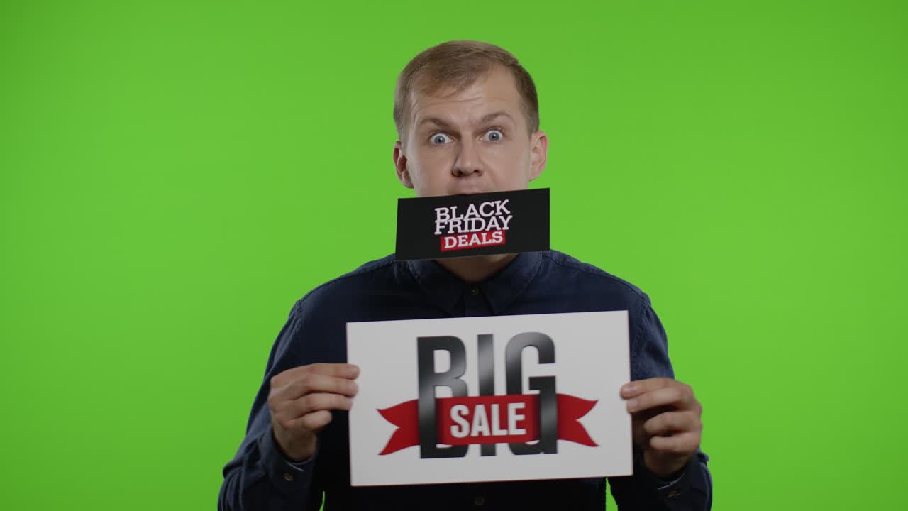 남자 쇼핑객은 그의 달에 블랙 프라이데이 거래 광고를 들고 큰 판매 문구를 보여줍니다.