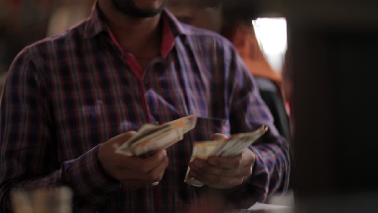 counting currancy red shirt market seller.