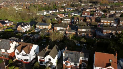 Aerial-view-expensive-British-middle-class-house-rooftops-in-rural-suburban-autumn-neighbourhood