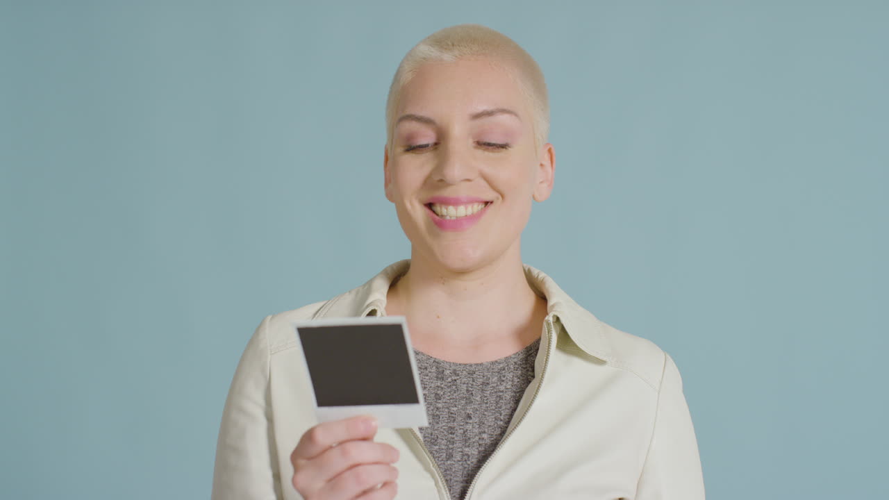 자신의 즉석 사진을 들고 있는 여성 백인 모델