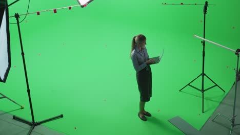 beautiful young woman wearing casual skirt and shirt, using laptop computer in green screen mock up chroma key studio. business, corporate office, work, technology concept.