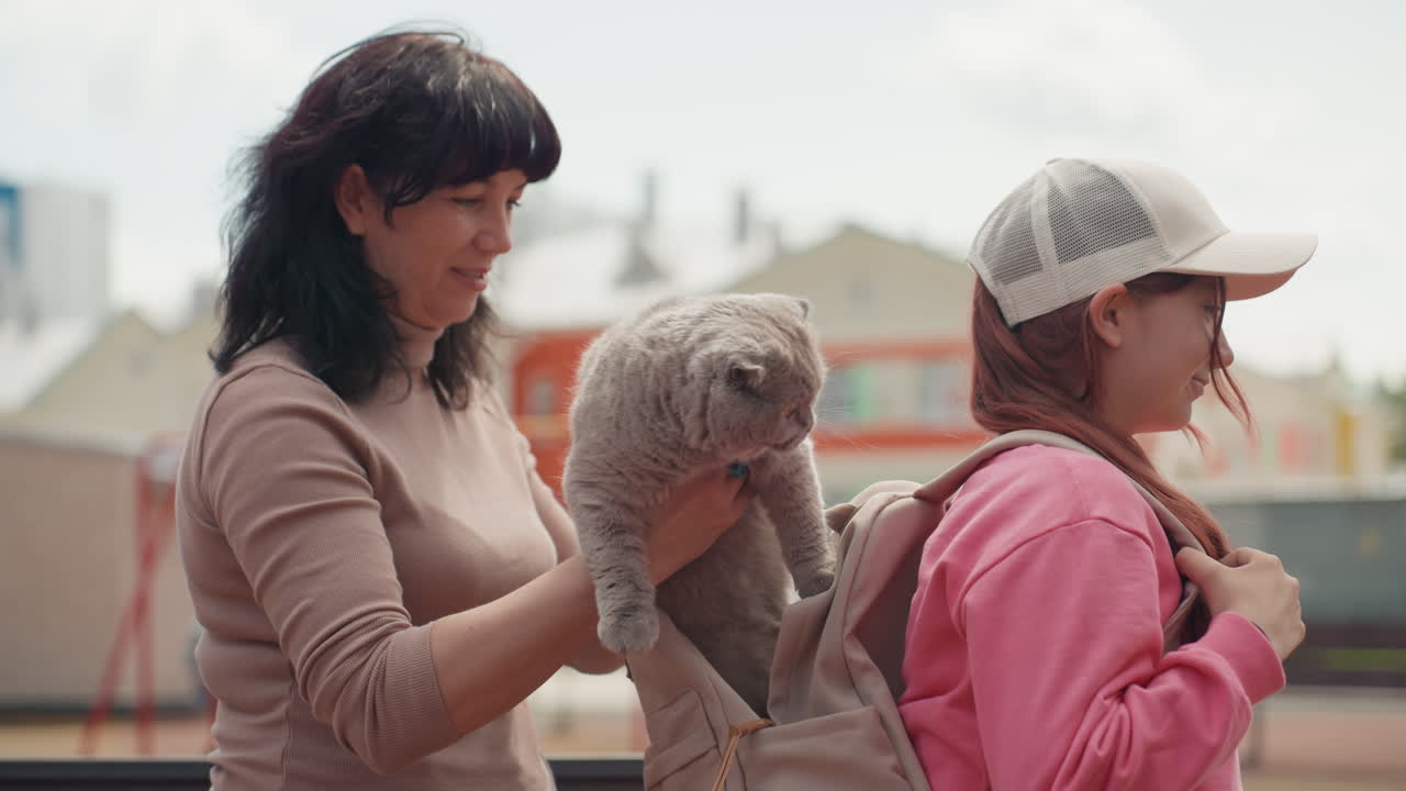 Mom Assists Daughter, Caregiver Helping Child Prepare For Outdoor Adventure With Affection, Family Bonding As Mother Assures Daughter With Gentle Touch And Warm Expressions In City Park