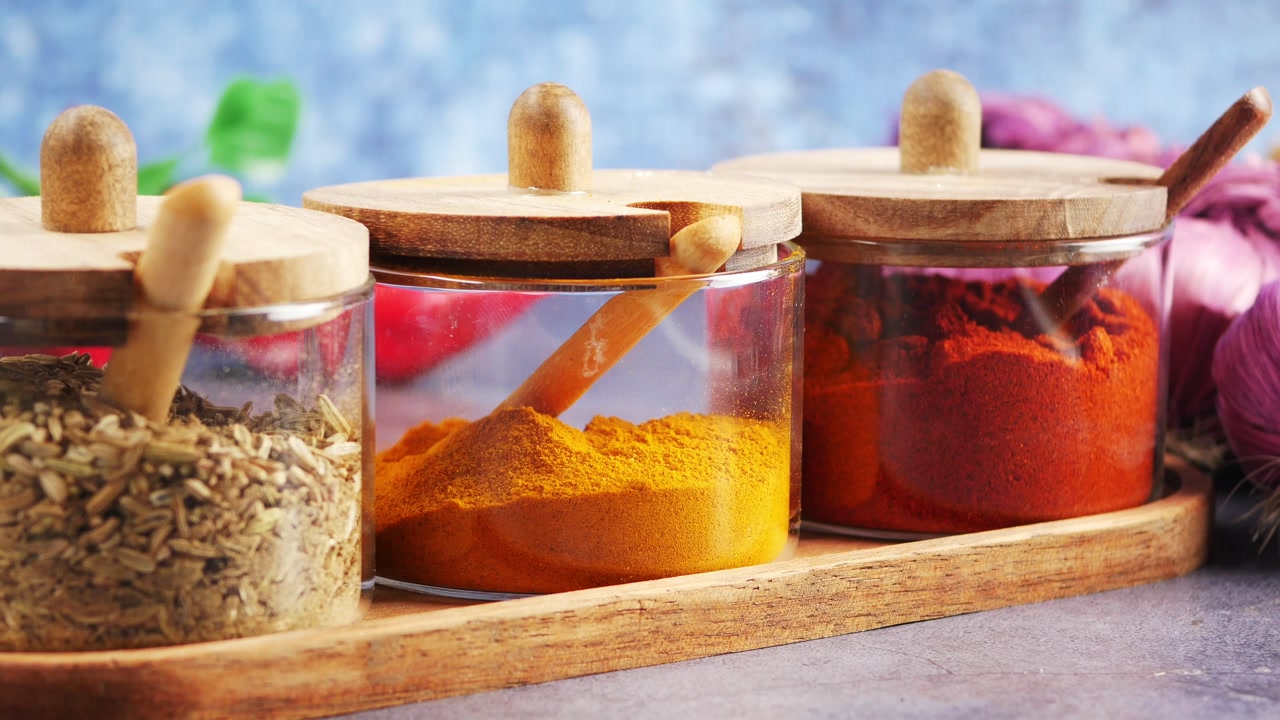 Close-up of Various Spices in Glass Jars on a Wooden Tray