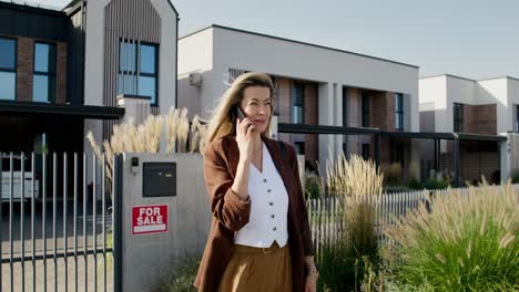 woman talking on phone near houses for sale