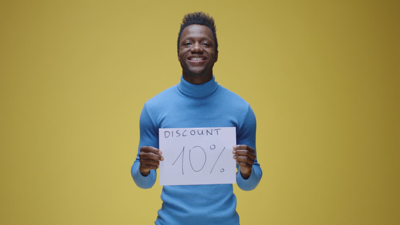 Smiling man holding a 10% discount sign
