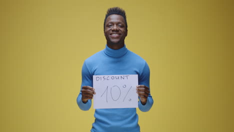 smiling man holding a 10% discount sign