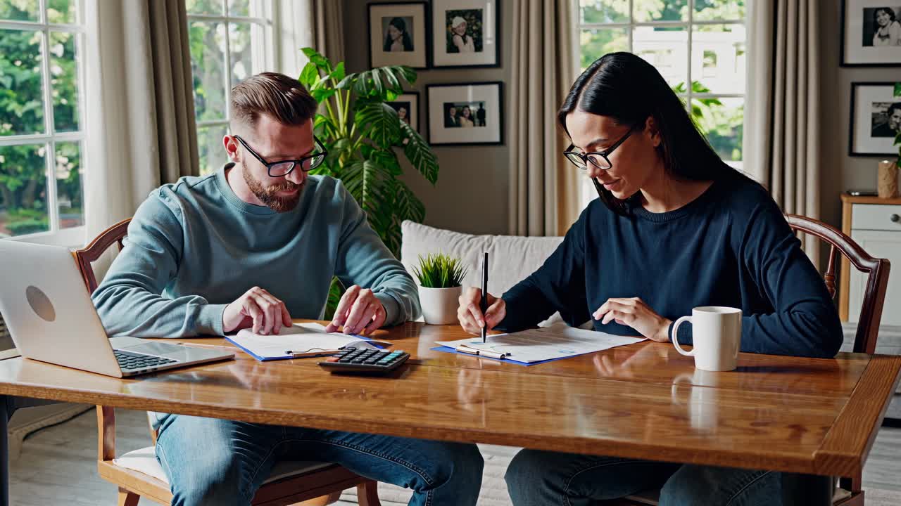 pareja revisando y firmando documentos en el hogar