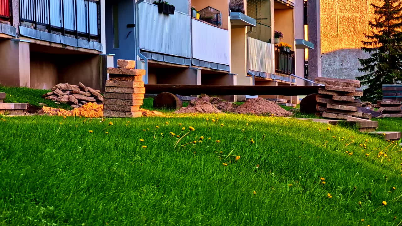 Residential Apartment Building Under Renovation With Paving Stones and Grass