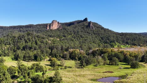 panoramic view of nimbin rocks under clear blue skies, showcasing lush greenery and rugged terrain