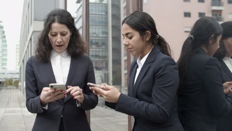 Mujeres-Empresarias-Hablando-Y-Usando-Teléfonos-Inteligentes