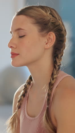 young woman with braids meditating in a gym