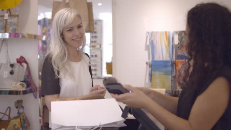 happy fashion store customer paying for purchase