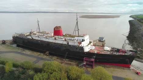 decaying rusty tss duke of lancaster ship, aerial fly forward view