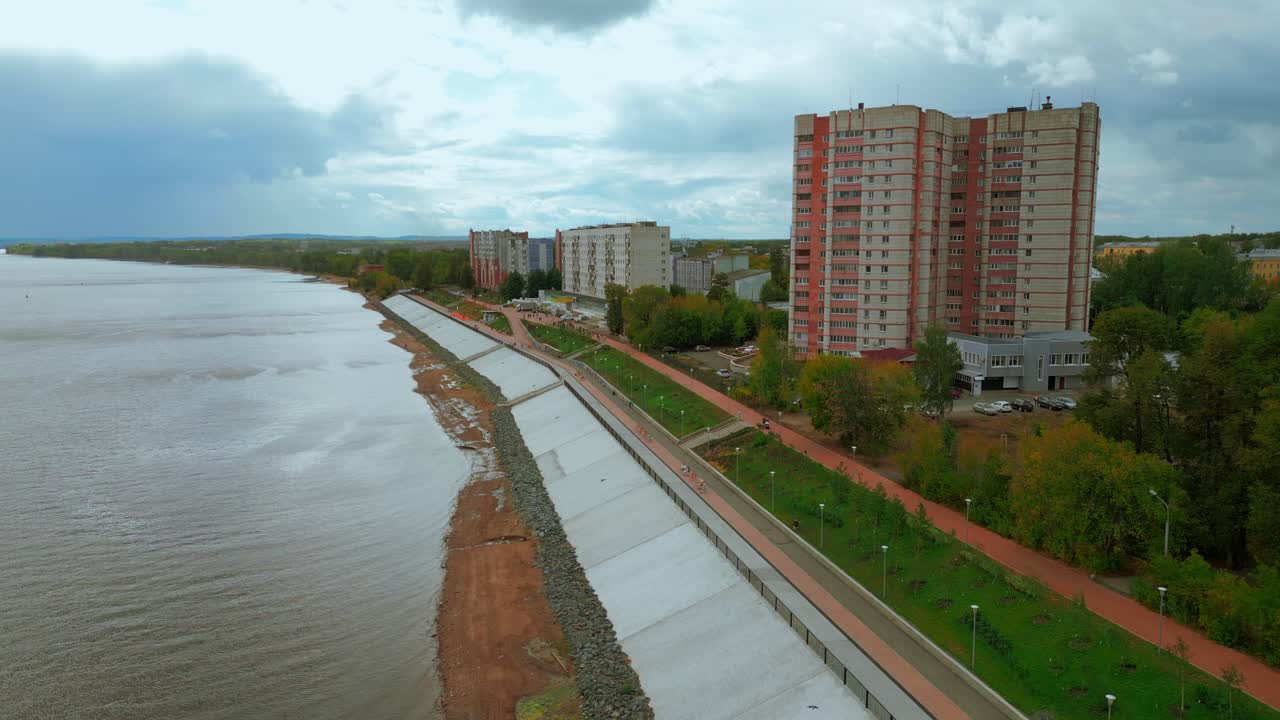 городской пейзаж на берегу реки с многоквартирными домами и пешеходной дорожкой